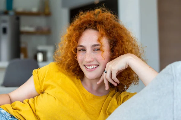 Young woman relaxing on her couch. Portrait of a beautiful woman smiling at home. woman in casual looking at camera with copy space.