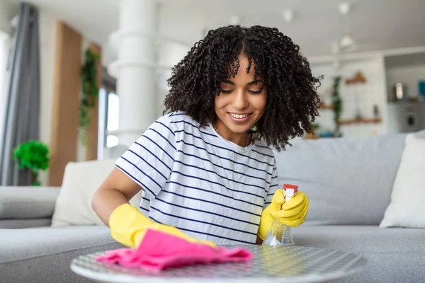 Beautiful young woman makes cleaning the house. Girl rubs dust. cleaning table and spraying disinfectants, Using cleaning solutions or using alcohol to kill germs.