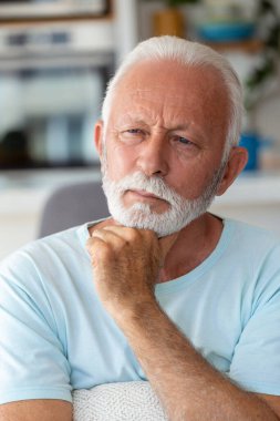 Düşünceli kıdemli adam evde dinleniyor. Son sınıf öğrencisinin yakın plan çekimleri.