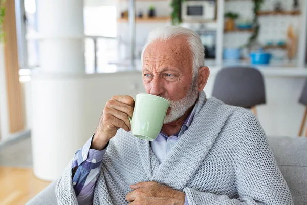 Evdeki Kanepede Battaniyeye Sarılı Otururken Grip Olup Çay Içen Yaşlı — Stok fotoğraf