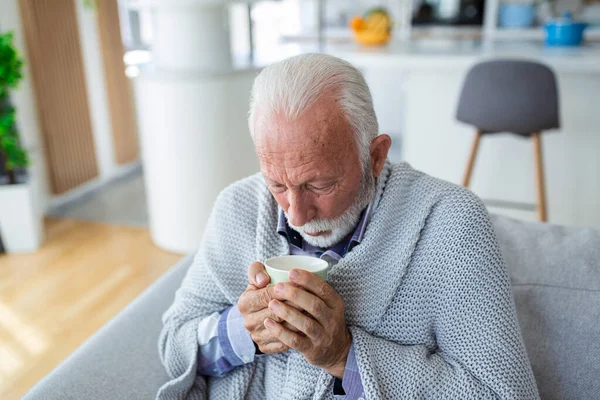 Evdeki Kanepede Battaniyeye Sarılı Otururken Grip Olup Çay Içen Yaşlı — Stok fotoğraf