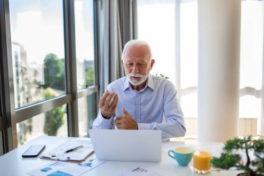 Yakışıklı kıdemli işletme koçunun portresi video görüşmesi yapıyor, kamerayla konuşuyor, bir şeyleri açıklıyor. Webinar, video konferansı, online toplantı konsepti