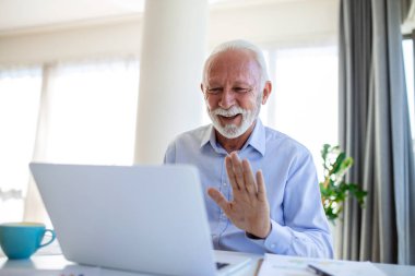 Yakışıklı kıdemli işletme koçunun portresi video görüşmesi yapıyor, kamerayla konuşuyor, bir şeyleri açıklıyor. Webinar, video konferansı, online toplantı konsepti