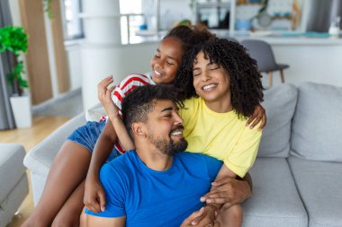 Farklı aileleri seven aileler küçük sevimli kızlarıyla vakit geçirir. Modern evde birlikte eğlenirler. Gülerek, yakından. Mutlu çoklu etnik aile kavramı