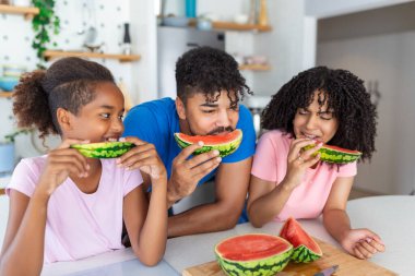 Neşeli baba ve küçük kızının karpuz yerken mutlu göründükleri yakın çekim..