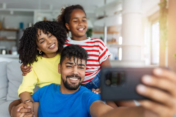 全长微笑的父亲拿着手机 带着幸福的妻子和女儿录制视频 兴奋的父母看着女儿的手机屏幕 感到兴奋 — 图库照片