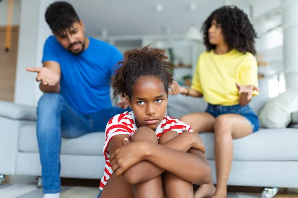 家庭误解 童年问题 伤心的黑人女儿坐在地板上 在家里吵架后又回到父母身边 让妈妈和爸爸很生气 问她怎么了 — 图库照片