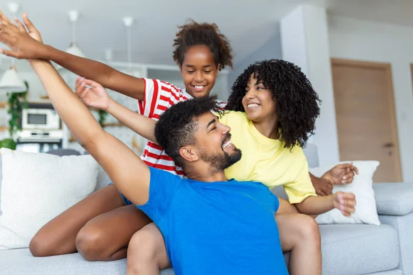 Family sitting on sofa smiling at camera on modern apartment background Happy family with daughter playing at home and weekend for family