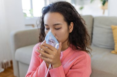 Sick Asian woman making inhalation, medicine is the best medicine. Ill woman wearing an oxygen mask and undergoing treatment for covid-19. woman with an inhaler