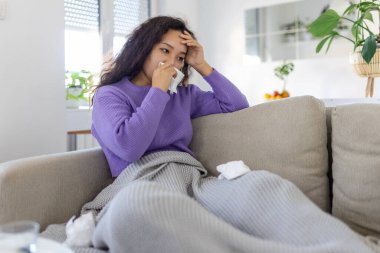 Sick desperate woman has flu. Rhinitis, cold, sickness, allergy concept. Asian sick woman has runnning nose, rubs nose with handkerchief. Sneezing female. Brunette sneezing in a tissue