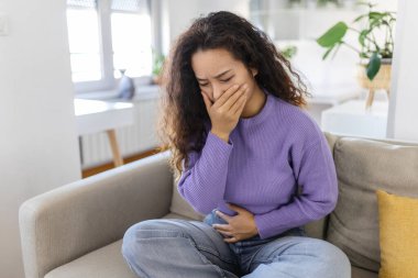 Asyalı mutsuz, rahatsız, kusmak, kusmak üzere olan hasta bir kadının yakın plan portresi. Olumsuz duygular, duygular, yüz ifadeleri. Sabah bulantısı olan Asyalı kadın..