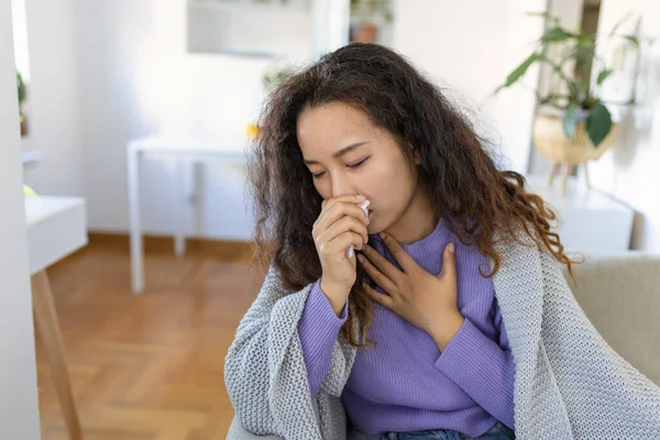 Cold ,flu cough. Sick woman coughing sitting on sofa at home . Asian woman being sick having flu lying on sofa. Cold flu coronavirus, covid19