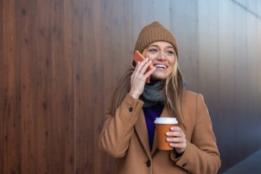 Ofis binasının yakınındaki kahve dükkanında güzel bir kadın işe gidiyor. Başarılı İş Kadını Portresi Sıcak İçki Kadehi.