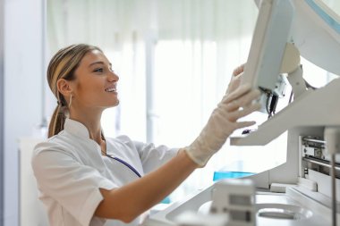 Research Scientists Working On Computer, with Medical Equipment, Analyzing Blood and Genetic Material Samples with Special Machines in the Modern Laboratory.