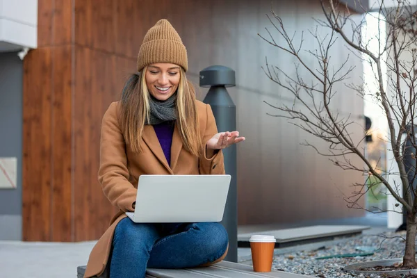 Beautiful Young Woman Wearing Autumn Coat Using Laptop While Sitting — Stok fotoğraf