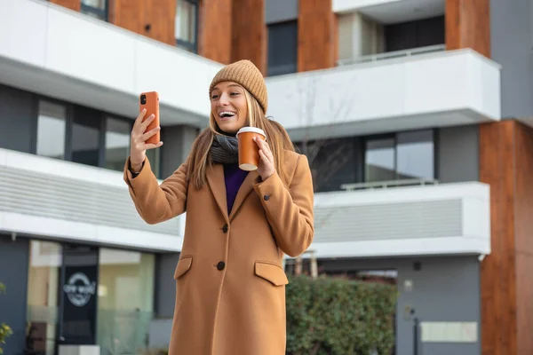 Веселая Молодая Женщина Пальто Используя Свой Телефон Солнечной Улице Города — стоковое фото