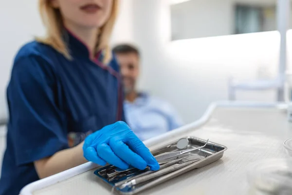 Detail of hand holding dental tools in dental clinic. Dentist Concept. Dental equipment and dental instruments used in the treatment of dental and dentistry by dentist.