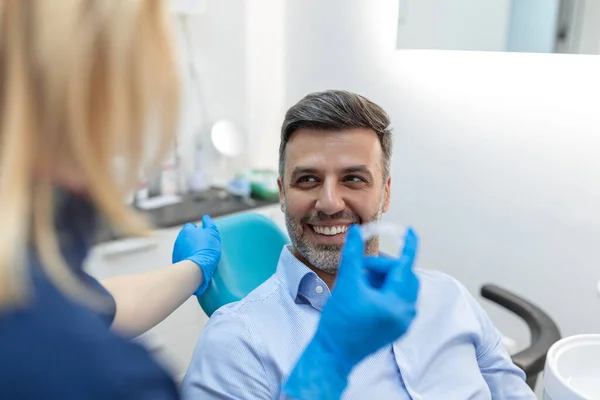 歯科医院 歯の検査および健康な歯の概念の患者への洞察力を示す若い女性歯科医 — ストック写真