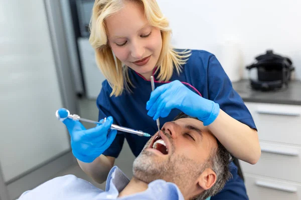 歯科医の手の保持ツールと手の注射器の閉鎖 痛みを伴う殺人者 男性のクライアントは口を開いておく 美しい笑顔と白い歯 カットビュー — ストック写真