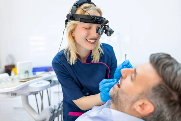 拡大鏡付き男性患者を調べる歯科医 — ストック写真