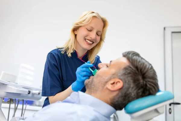 Female Dentist Treating Teeth Patient Mid Age Man Chair Dental — Stock Photo, Image
