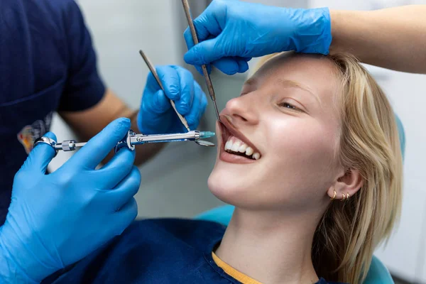 Painkiller anesthesia injection. Dentist examining a patient\'s teeth in modern dentistry office. Closeup cropped picture with copyspace. Doctor in disposable medical facial mask.