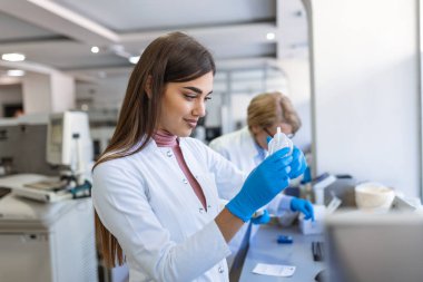 Kadın Tıbbi Araştırmacı Uygulamalı Bilim Laboratuvarı 'nda Dijital Mikroskop altında analiz etmeden önce Biyolojik Örnekleri inceliyor. Beyaz Önlüklü Laboratuar Mühendisi Aşı ve Tıp üzerine çalışıyor