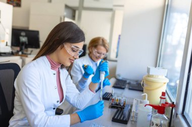 Modern Tıbbi Araştırma Laboratuvarı: Mikro Pipette ile çalışan Kadın Bilimadamı, Biyokimya Örnekleri Analizi. Gelişmiş Tıp, Mikrobiyoloji Geliştirme Laboratuvarı.