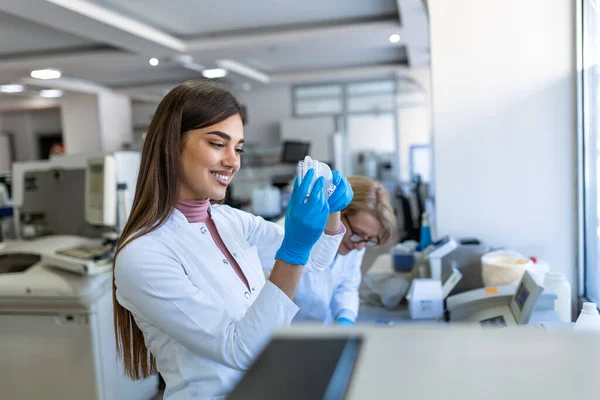 stock image Female Medical Research Scientist Looks at Biological Samples Before Analysing it Under Digital Microscope in Applied Science Laboratory. Lab Engineer in White Coat Working on Vaccine and Medicine