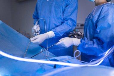 Cerrah enstrümanı hastanın karnına yerleştiriyor. Cerrah ameliyathanede laparoskopik ameliyat yapıyor. Minimum invazif ameliyat.