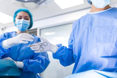 Ameliyathanede Düşük Açı Vuruşu, Ameliyat sırasında Cerrahlara Alet Verme. Cerrahlar ameliyat yapıyor. Profesyonel Tıp Doktorları Ameliyat Yapıyor.