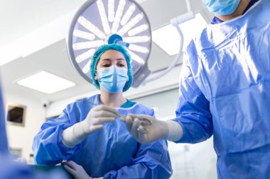 Ameliyathanede Düşük Açı Vuruşu, Ameliyat sırasında Cerrahlara Alet Verme. Cerrahlar ameliyat yapıyor. Profesyonel Tıp Doktorları Ameliyat Yapıyor.