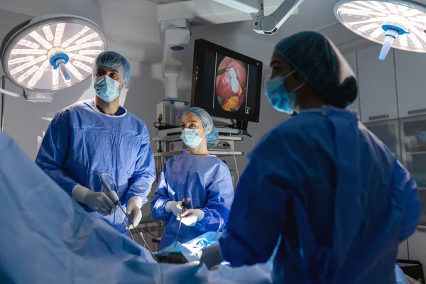 三个外科医生在做腹腔镜手术 医生看着监视器上的图像 医学和医疗保健概念 计算机显示器上看到的病人内部器官 — 图库照片