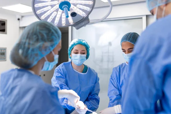 医師と看護師の医療チームが病院の緊急治療室で手術を行っています 手術中に手術室や手術器具を外科医に渡し — ストック写真