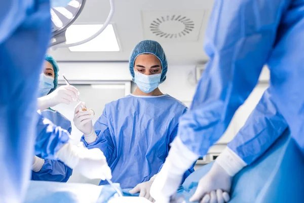 Χειρουργοί Που Λειτουργούν Κάτω Από Τον Εξοπλισμό Φωτισμού Αρσενικοί Και — Φωτογραφία Αρχείου