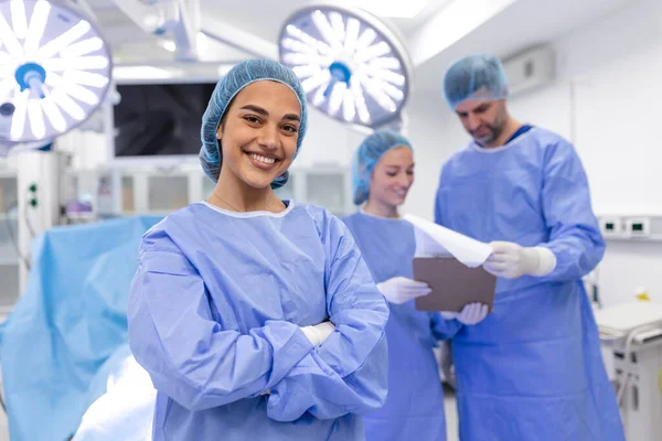 Close Surgeon Woman Looking Camera Colleagues Performing Background Operation Room — Φωτογραφία Αρχείου