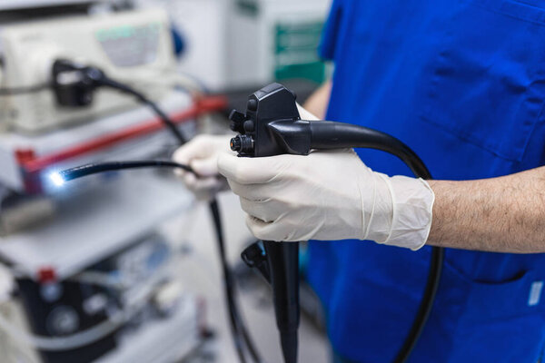 Doctor proctologist holding endoscope during colonoscopy. Probe colonoscope. Doctor gastroenterologist with probe to perform gastroscopy and colonoscopy