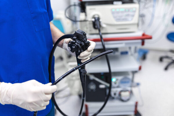 Doctor proctologist holding endoscope during colonoscopy. Probe colonoscope. Doctor gastroenterologist with probe to perform gastroscopy and colonoscopy