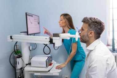 Adam klinikte spirometre kullanarak pulmoner fonksiyon testi ve spirometri yapıyor. Akciğerlerin Spirometrisi