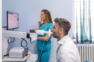 Solunum fonksiyonlarını spirometriyle test eden bir adam. Akciğer hastalığında solunum fonksiyonu teşhisi