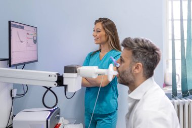 Yetişkin adam sprometri ile nefes alma fonksiyonlarını test ediyor. Sağlık sorunları var. Akciğer hastalığında solunum fonksiyonu teşhisi.