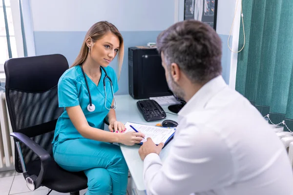 Serious Man Consulting Young Female Physician Doctor Checkup Meeting Hospital — Stock Photo, Image