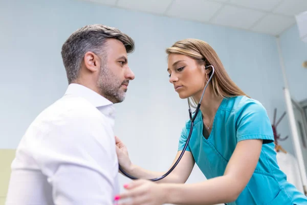 Młody Lekarz Używa Stetoskopu Słuchać Bicia Serca Pacjenta Strzał Kobiety — Zdjęcie stockowe