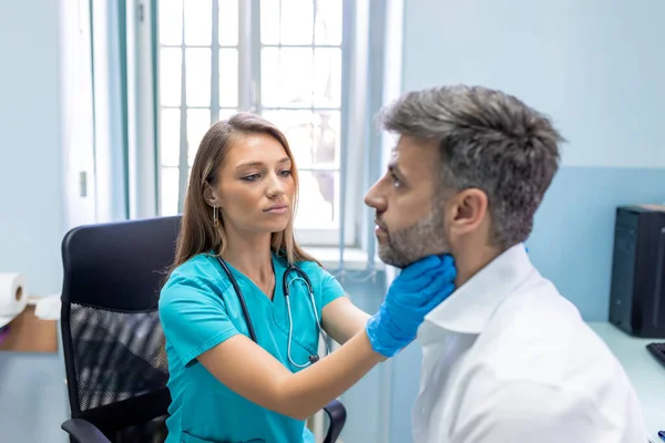内科医生在诊所检查人的喉咙 做甲状腺测试的男人内分泌学 激素和治疗 嗓子疼发炎 — 图库照片