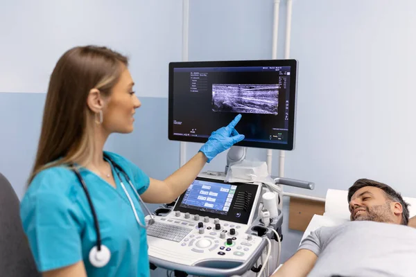 女医生在她的办公室里对病人的胳膊静脉进行超声波检查 在诊所通过超声波扫描的年轻人 医生的工作 医疗研究 — 图库照片
