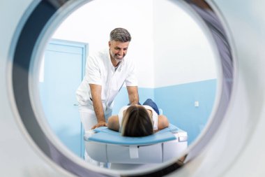 Tıbbi ekipman. Doktor ve hasta, hastanedeki bilgisayarlı tomografi odasında. Tomografi cihazıyla hastayı muayene eden doktor. Bilgisayarlı tomografi.