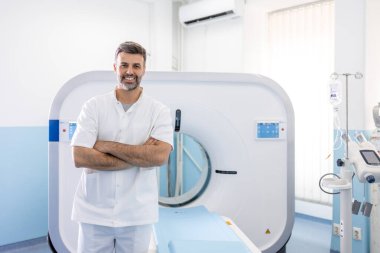 Modern bir hastanenin manyetik rezonans görüntüleme ya da bilgisayarlı tomografi odasında kendinden emin erkek doktor onkolojisi.