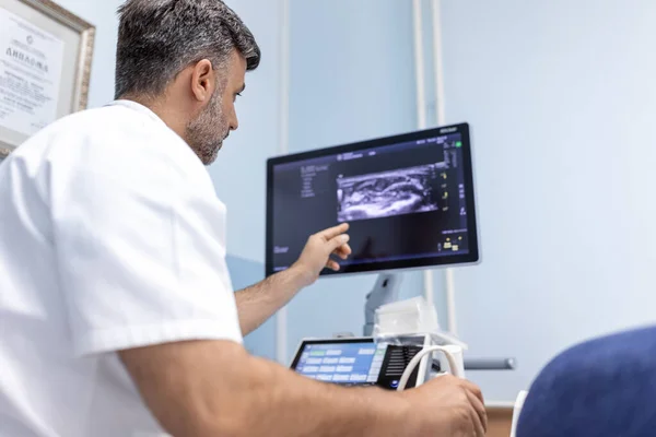 在医疗诊所 白人男医生对一名女病人的动脉和静脉进行多普勒超声检测 — 图库照片