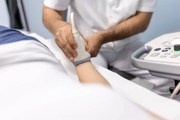 在医疗诊所 白人男医生对一名女病人的动脉和静脉进行多普勒超声检测 — 图库照片