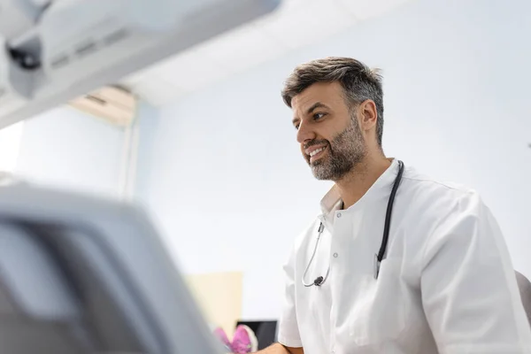 医療クリニックでは 白人男性医師が女性患者の動脈と静脈のドップラー超音波検査評価を行っています — ストック写真